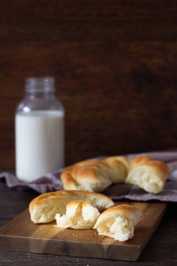 Ahşap masa üzerinde süt şişesiyle taze lezzetli ekmek.