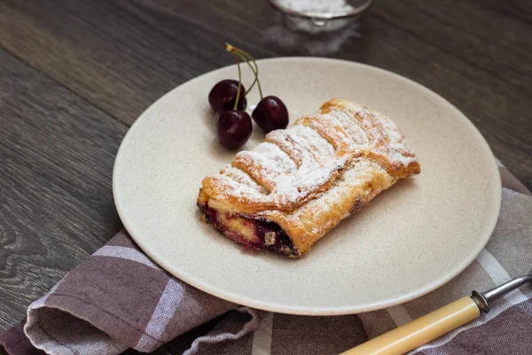 Lezzetli ev yapımı puf böreği doldurma kiraz ile pudra şekeri ile dekore edilmiştir. Bisküvi ile meyve doldurma 