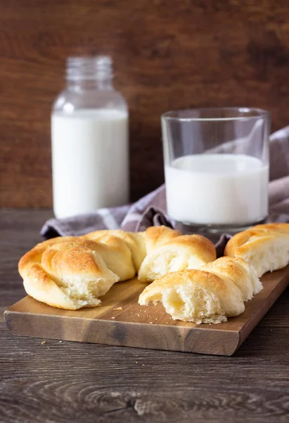Ahşap masa üzerinde süt şişesiyle taze lezzetli ekmek.