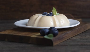 Kahve süt jöle veya ekşi krema, yaban mersini ve nane beyaz tabakta panna cotta