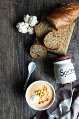 Karnabahar, nohut ve ekşi krema koyu ahşap arka plan, üstten görünüm üzerinde krem çorbası. Sağlıklı gıda kavramı 