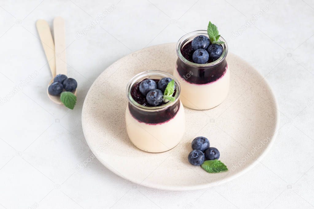 Coffee panna cotta with berry coulis and fresh blueberries. Delicious Italian dessert panna cotta