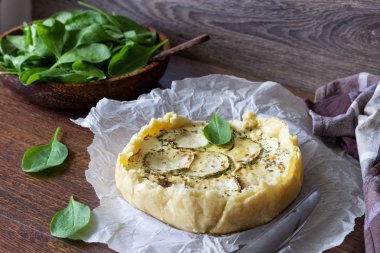 Ev yapımı lezzetli kabak quiche ile yumurta, süt ve peynir, yuvarlak bir ahşap tahta üzerinde şeklinde. Rustik tarzı. Geleneksel Fransız kiş pasta.
