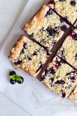 Limon, siyah frenk üzümü ve bir kağıt üzerinde streusel ile peynirli kek barlar.