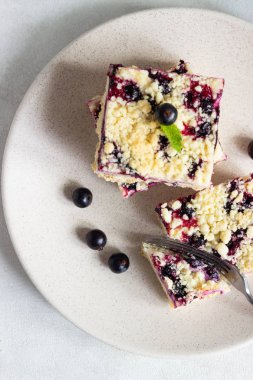 Siyah frenk üzümü kek. Limon, siyah frenk üzümü ve bir plaka üzerinde streusel ile peynirli kek barlar.