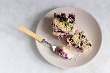 Siyah frenk üzümü kek. Limon, siyah frenk üzümü ve bir plaka üzerinde streusel ile peynirli kek barlar.