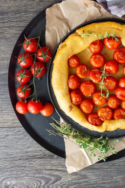 Puf böreği çiğ domatesli ve koyu ahşap zemin üzerine kekik kiraz domates ile ev yapımı tart. Domates tart tatin. Rustik tarzı.
