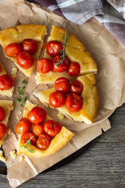 Puf böreği çiğ domatesli ve koyu ahşap zemin üzerine kekik kiraz domates ile ev yapımı tart. Domates tart tatin. Rustik tarzı.