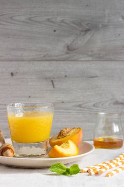 Şeftali yüzlü bir tabak taze şeftali, bal ve nane ile cam. Sağlıklı içecek. Odaya Servis Kahvaltı veya aperatif. Kopya alanı