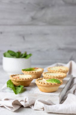 Mini tartlets krem peynir dolum ve beyaz tahta kesme tahtası somon ile.