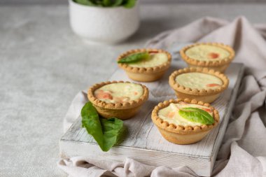 Mini tartlets krem peynir dolum ve beyaz tahta kesme tahtası somon ile.