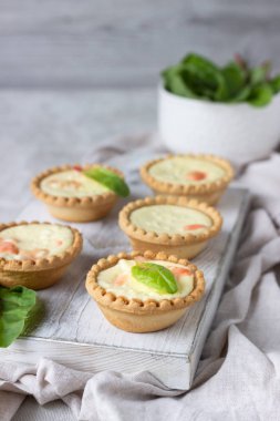 Mini tartlets krem peynir dolum ve beyaz tahta kesme tahtası somon ile.
