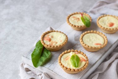 Mini tartlets krem peynir dolum ve beyaz tahta kesme tahtası somon ile.