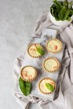 Mini tartlets krem peynir dolum ve beyaz tahta kesme tahtası somon ile.