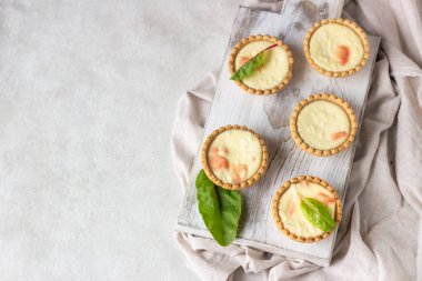 Mini tartlets krem peynir dolum ve beyaz tahta kesme tahtası somon ile.