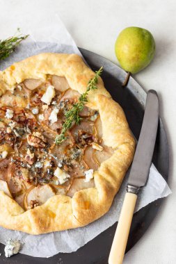 Ev yapımı rustik Galette'ye armut, mavi peynir, ceviz ve açık renkli tatlım. Tepeye bir tereyağlı kabuk ve tatlı meyve dolgu ile. Rustik tarzı.