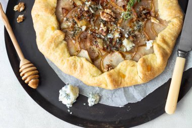 Ev yapımı rustik Galette'ye armut, mavi peynir, ceviz ve açık renkli tatlım. Tepeye bir tereyağlı kabuk ve tatlı meyve dolgu ile. Rustik tarzı.