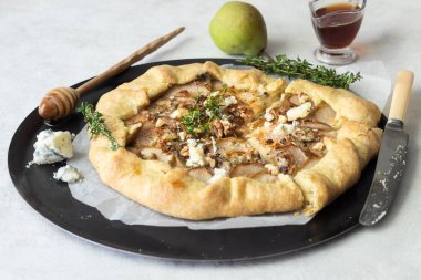 Ev yapımı rustik Galette'ye armut, mavi peynir, ceviz ve açık renkli tatlım. Tepeye bir tereyağlı kabuk ve tatlı meyve dolgu ile. Rustik tarzı.