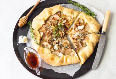 Ev yapımı rustik Galette'ye armut, mavi peynir, ceviz ve açık renkli tatlım. Tepeye bir tereyağlı kabuk ve tatlı meyve dolgu ile. Rustik tarzı.