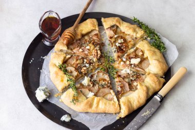 Ev yapımı rustik Galette'ye armut, mavi peynir, ceviz ve açık renkli tatlım. Tepeye bir tereyağlı kabuk ve tatlı meyve dolgu ile. Rustik tarzı.