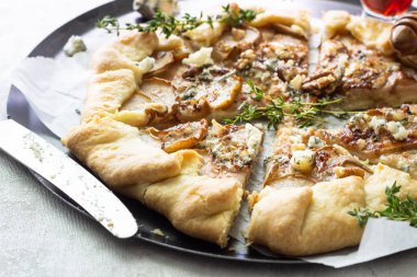 Ev yapımı rustik Galette'ye armut, mavi peynir, ceviz ve açık renkli tatlım. Tepeye bir tereyağlı kabuk ve tatlı meyve dolgu ile. Rustik tarzı.