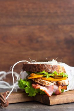 Yeşil salata, ızgara Türkiye, pastırma ve ahşap kesme tahtası üzerinde sebze ile iki sandviç. Öğle yemeği kavramı.