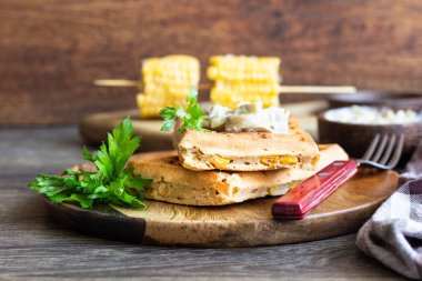 Rustik bir arka plan üzerinde ahşap bir tabakta Mısır ve mantar kremalı sos ile tuzlu waffle