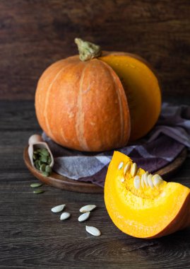 Taze turuncu kabak çiğ kabak çekirdeği, rustik tarzı ile ahşap bir tabakta. Turuncu Halloween balkabağı. Tatil dekorasyon.