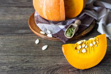 Taze turuncu kabak çiğ kabak çekirdeği, rustik tarzı ile ahşap bir tabakta. Turuncu Halloween balkabağı. Tatil dekorasyon.