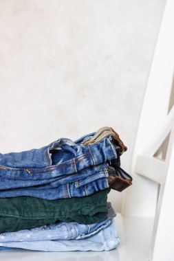 Kot pantolon beyaz bir sandalyenin üstüne yığılmış.