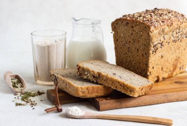 Ahşap kesme tahtası üzerinde tam tahıl çavdar ekmeği tohumları ile dilimlenmiş. 