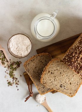 Ahşap kesme tahtası üzerinde tam tahıl çavdar ekmeği tohumları ile dilimlenmiş. 