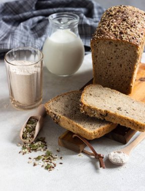Ahşap kesme tahtası üzerinde tam tahıl çavdar ekmeği tohumları ile dilimlenmiş. 