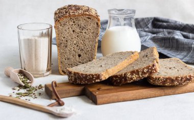 Ahşap kesme tahtası üzerinde tam tahıl çavdar ekmeği tohumları ile dilimlenmiş. 