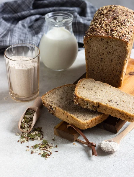 Ahşap kesme tahtası üzerinde tam tahıl çavdar ekmeği tohumları ile dilimlenmiş. 