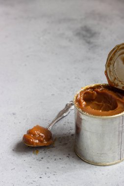 Dulce de leche doğal taş zemin üzerine metal teneke içinde.