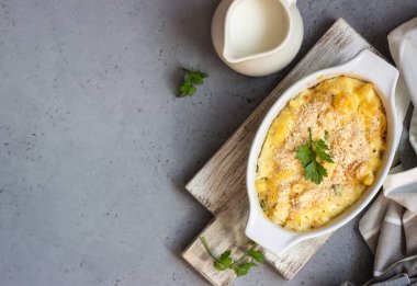 Balık ve yeşil bezelye beşamel sos içinde ışık kayrak, taş veya beton arka plan üzerinde bir pişirme çanağı ile ev yapımı makarna güveci. Metin için yer kopyalayın.