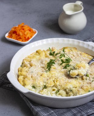 Balık ve yeşil bezelye beşamel sos içinde ışık kayrak, taş veya beton arka plan üzerinde bir pişirme çanağı ile ev yapımı makarna güveci. Metin için yer kopyalayın.