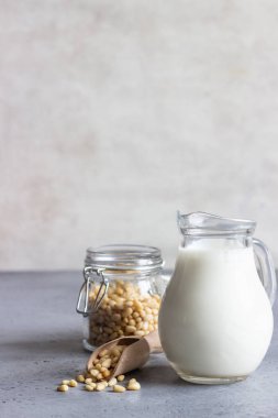 Sedir süt süt kabı ve çam fıstığı gri beton zemin üzerine.