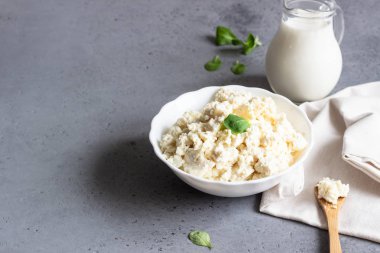 Organik ricotta peyniri beyaz kase mısır salata ve süt kabı.
