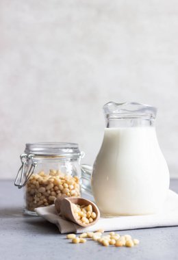 Sedir süt süt kabı ve çam fıstığı gri beton zemin üzerine.