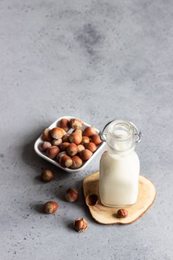 Şişe gri beton zemin üzerine fındık süt.