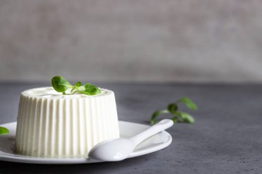 İtalyan ricotta veya taze çiftlik peynirli mısır salata gri beton zemin üzerine beyaz tabakta. Metin için yer kopyalayın.