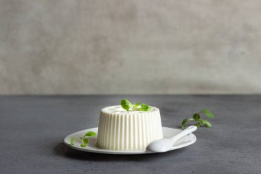 İtalyan ricotta veya taze çiftlik peynirli mısır salata gri beton zemin üzerine beyaz tabakta. Metin için yer kopyalayın.