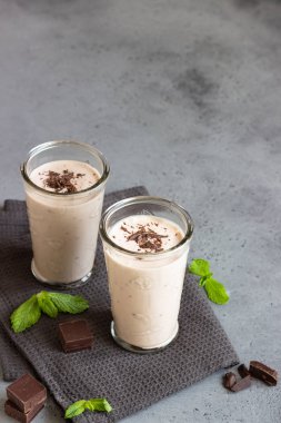 Gözlük gri beton zemin üzerine çikolata parçaları ile lezzetli çikolata meşrubatının (milkshake, kokteyl ya da iki yüzlü).