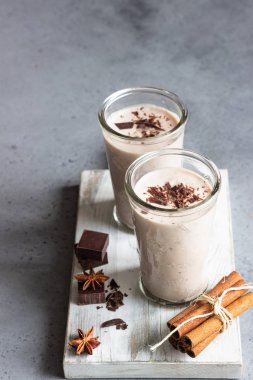 Gözlük gri beton zemin üzerine çikolata parçaları ile lezzetli çikolata meşrubatının (milkshake, kokteyl ya da iki yüzlü).