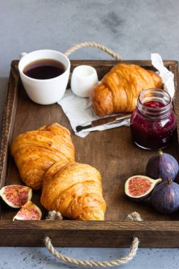 Eski ahşap tepsi fincan kahve, reçel kavanoz, taze incir ve ay çöreği. Kahvaltı saati