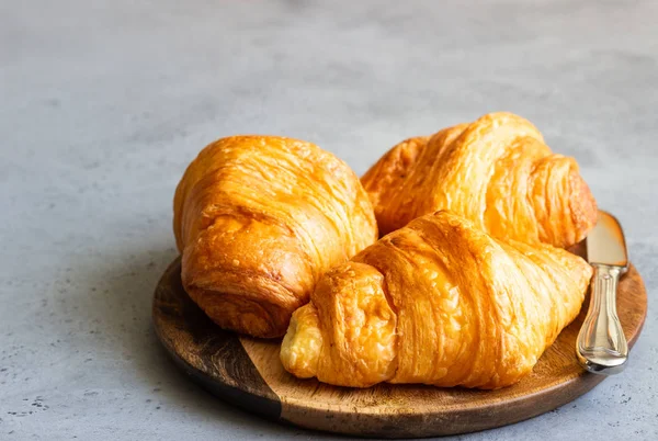 Croissants Mantequilla Fresca Placa Madera Sobre Fondo Hormigón Gris — Foto de Stock