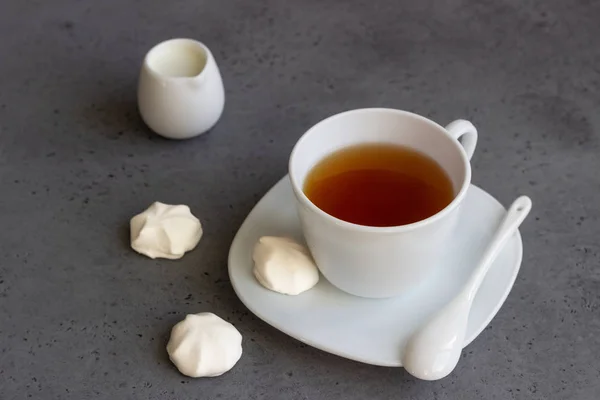 A cup of black tea with white mini marshmallow (homemade white zephyr). Copy space