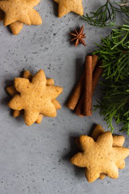 Geleneksel Noel gingerbread çerezleri ve ardıç şube ile Noel dekor gri beton zemin üzerine. Metin için yer kopyalayın.